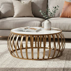 Round wooden coffee table with a vase and books in a living room setting.