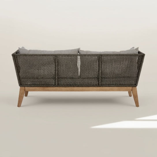 Wicker outdoor sofa with wooden legs on a white background