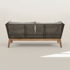 Wicker outdoor sofa with wooden legs on a white background