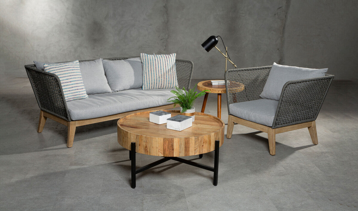 Outdoor furniture set with a sofa, chair, and coffee table on a concrete floor.