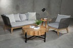 Outdoor furniture set with a sofa, chair, and round table on a concrete floor.