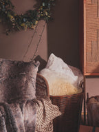 Wicker basket with decorative items against a dark wall