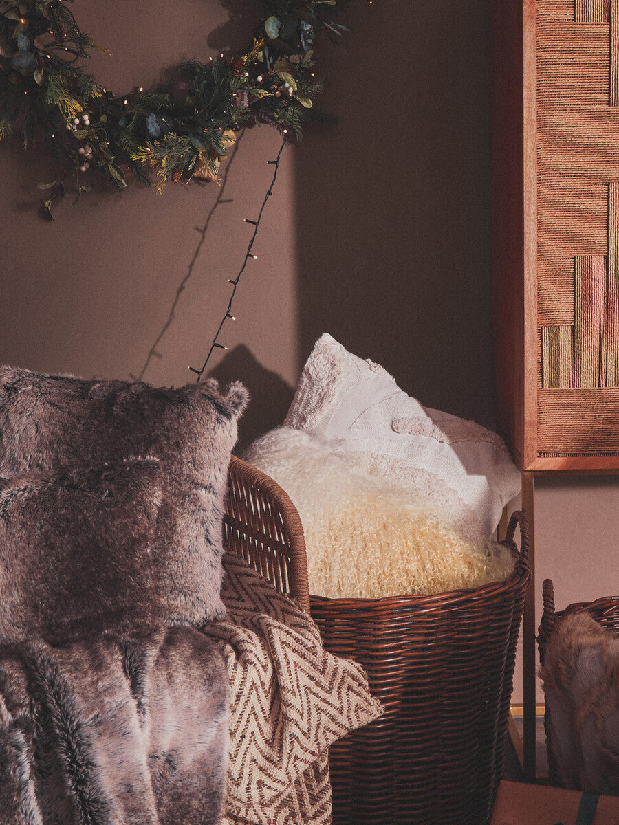 Wicker basket with decorative items against a dark wall