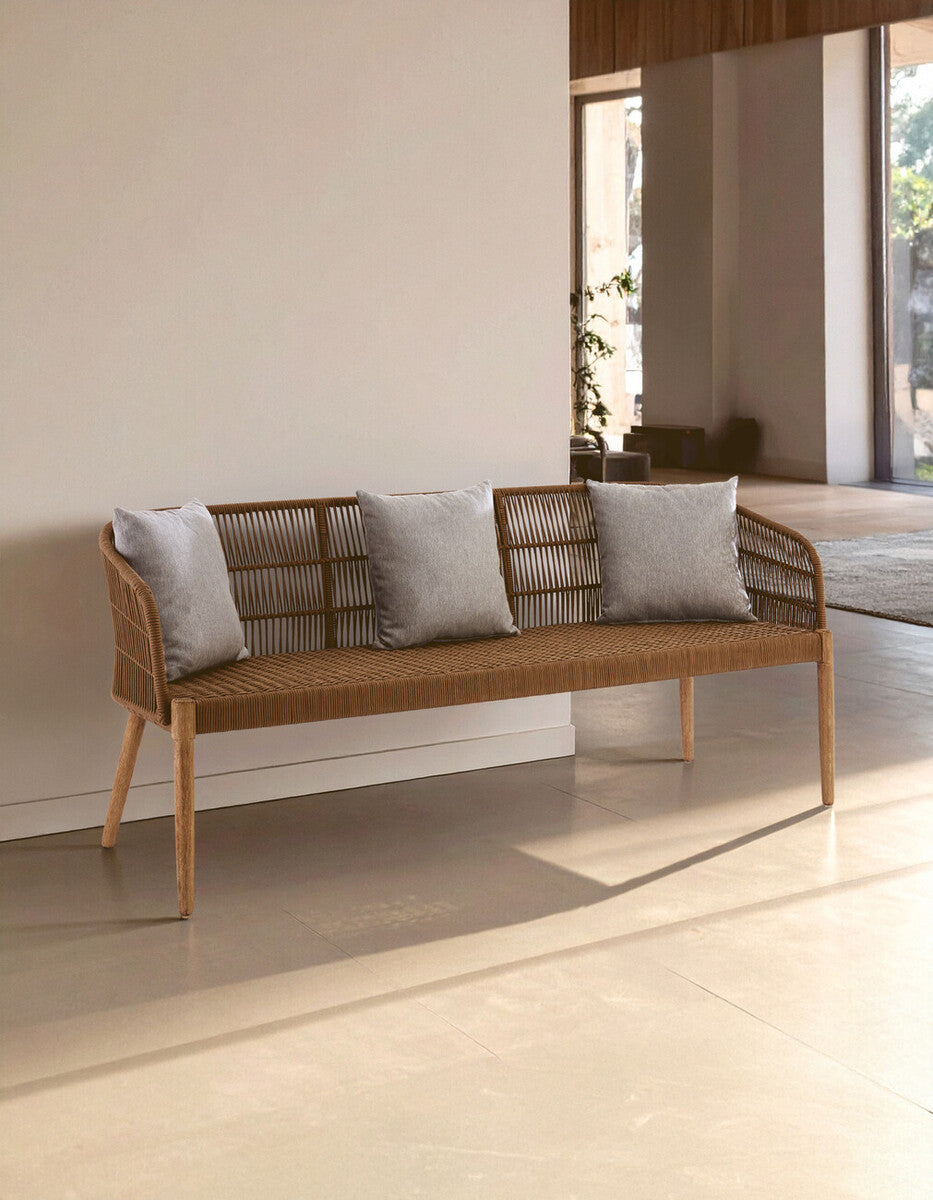 Wicker bench with gray cushions in a modern indoor setting