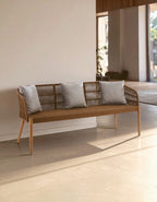 Wicker bench with gray cushions in a modern indoor setting