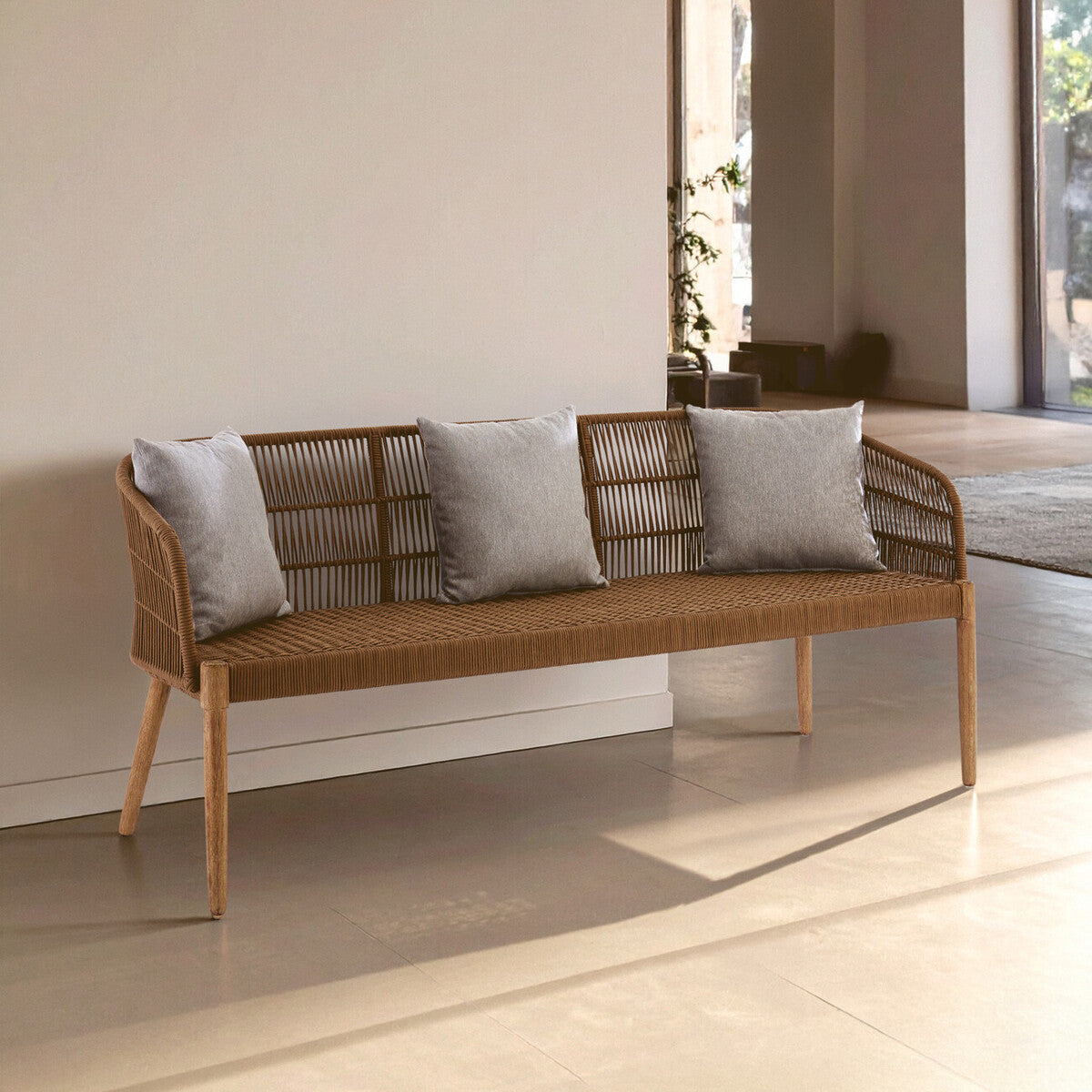 Wicker bench with gray cushions in a modern indoor setting
