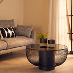 Modern living room with a sofa, coffee table, and decorative plants.