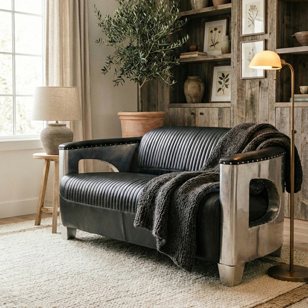 Modern black sofa with metallic legs in a stylish living room.