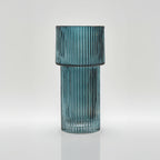 Teal ribbed glass vase on a white background