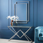 Modern console table with decorative items against a blue paneled wall.