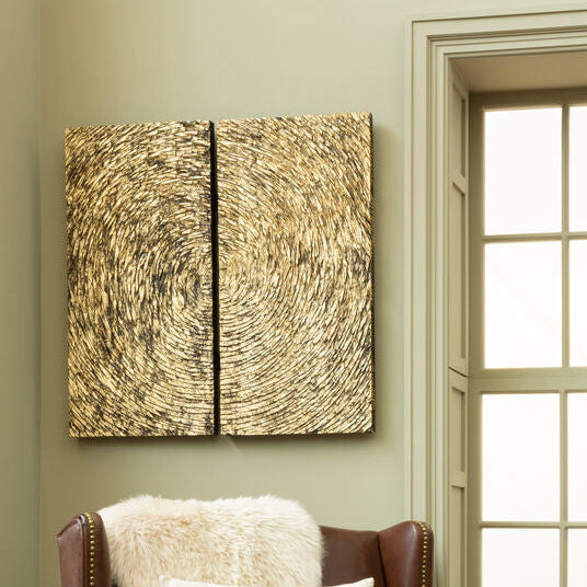 Abstract wall art with concentric circles on a beige wall next to a window.