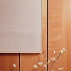 Close-up of a wooden panel with a neutral-colored wall in the background