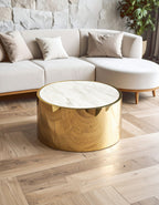 Gold coffee table in a living room with a white sofa and wooden floor.