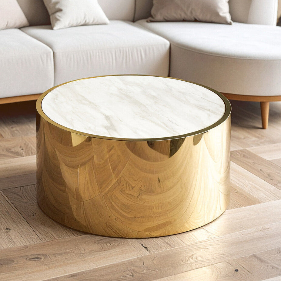 Round gold coffee table with marble top in a living room setting