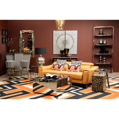 Modern living room with a yellow sofa, patterned rug, and decorative items.