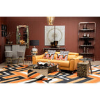 Modern living room with a yellow sofa, patterned rug, and decorative items.