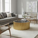 Modern living room with a gold coffee table, gray sofa, and wooden armchair.