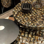 Round table with a patterned top and metallic base in an indoor setting