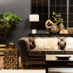 Living room with a brown leather sofa, decorative pillows, and a coffee table.