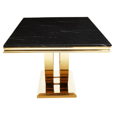 Square table with black marble top and gold base on a white background