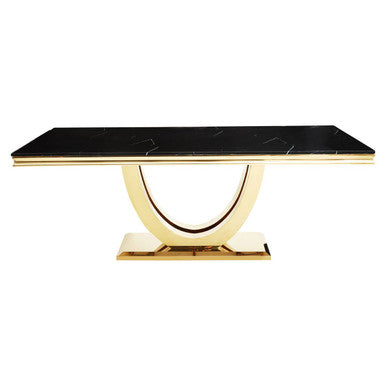 Dining table with black marble top and gold base on a white background