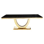 Dining table with black marble top and gold base on a white background
