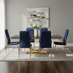 Dining room with a gold table and blue chairs, featuring a abstract painting on the wall.