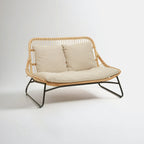 Wicker chair with beige cushions on a white background