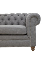 Gray tufted sofa with wooden legs on a white background