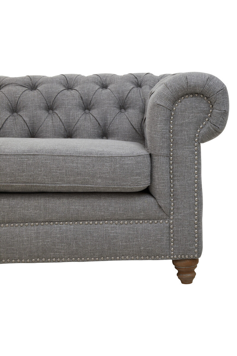 Gray tufted sofa with wooden legs on a white background