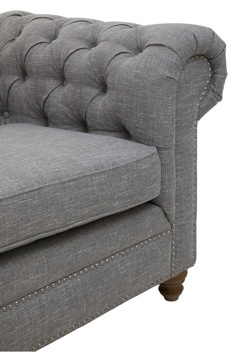 Gray tufted sofa with wooden legs on a white background
