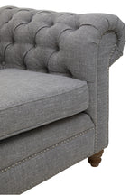 Gray tufted sofa with wooden legs on a white background