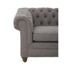 Gray tufted sofa with nailhead trim on a white background