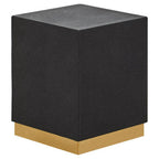 Black cube-shaped stool with a gold base on a white background
