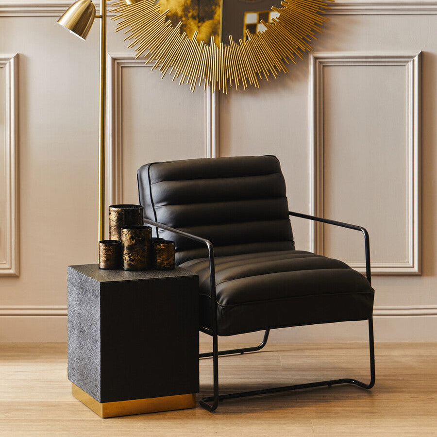 Modern black leather armchair in a stylish room with decorative elements.