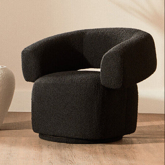 Black boucle chair on a wooden floor with a neutral background