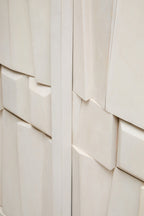 Close-up of a textured white wall with geometric patterns