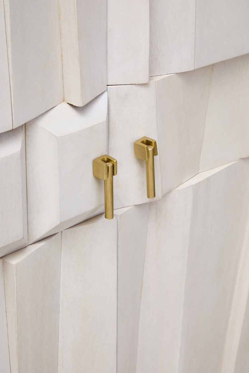 Close-up of a white cabinet with gold handles