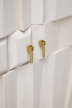 Close-up of a white cabinet with gold handles