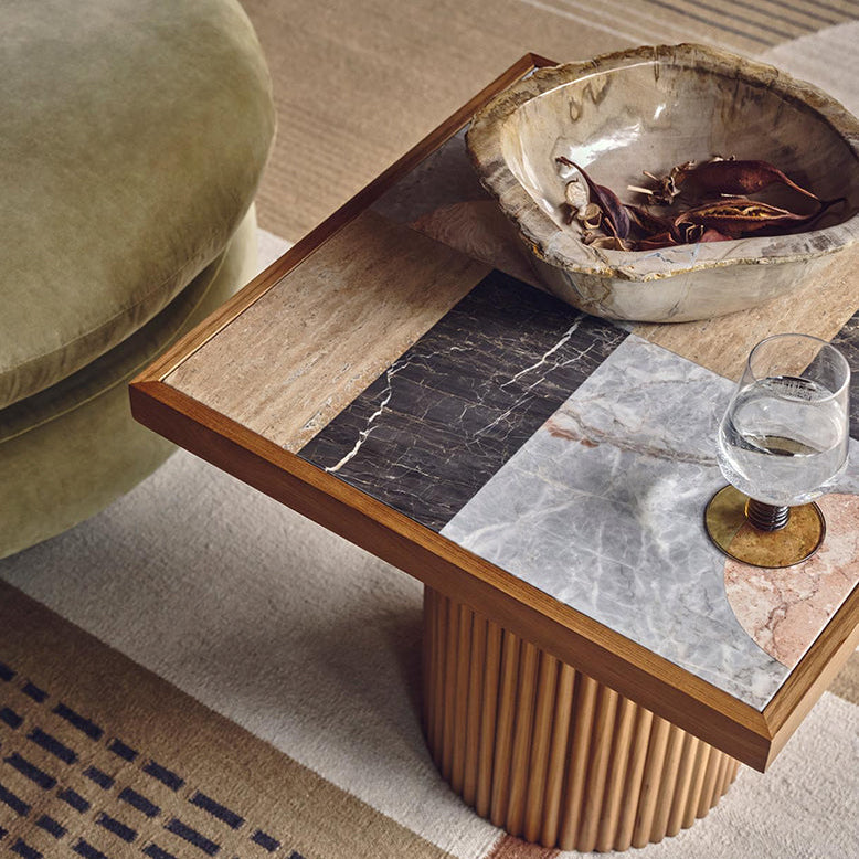 Coffee table with a decorative bowl and glass on a patterned rug