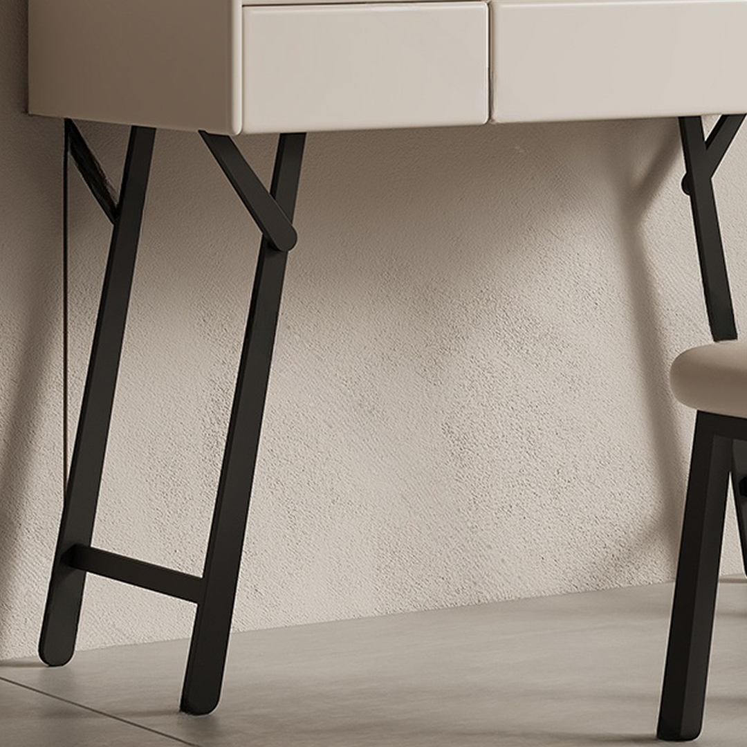 Close-up of a modern desk with black legs against a textured wall.
