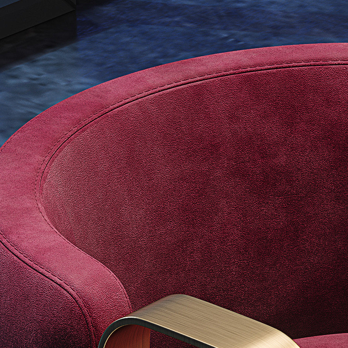 Close-up of a red upholstered chair with a gold armrest against a dark background