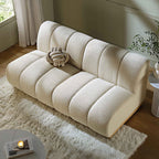 Beige sofa in a living room setting with a small table and plant.
