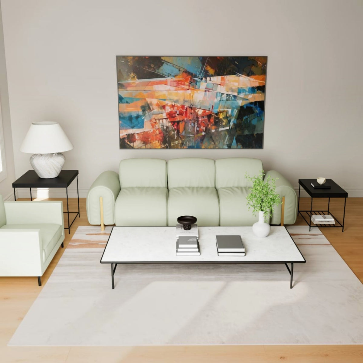 A modern living room setup featuring a light sage green three-seater sofa, a matching armchair, a white coffee table with black legs, black side tables, and a large colorful abstract painting on the wall.