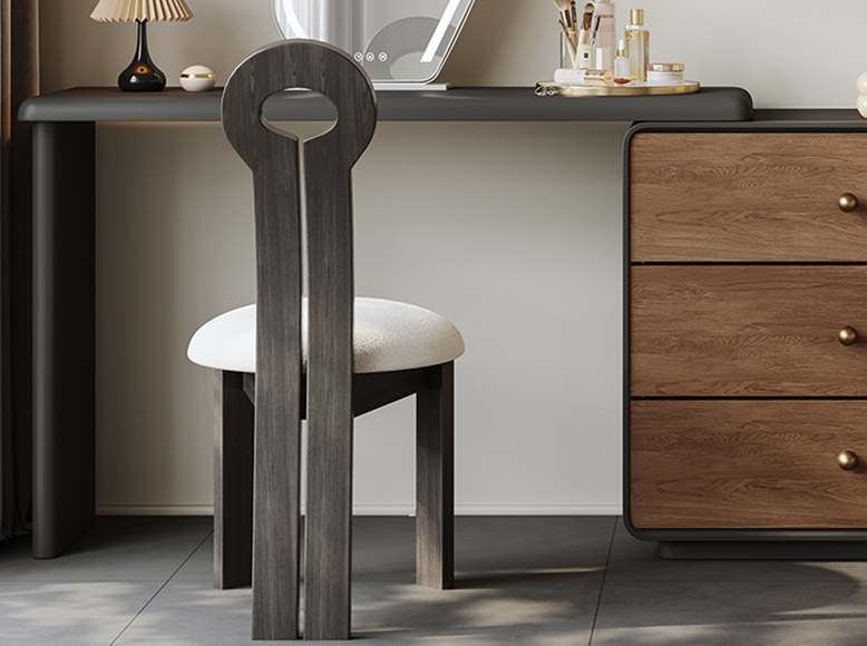 Wooden chair with a white cushion in front of a wooden dresser.