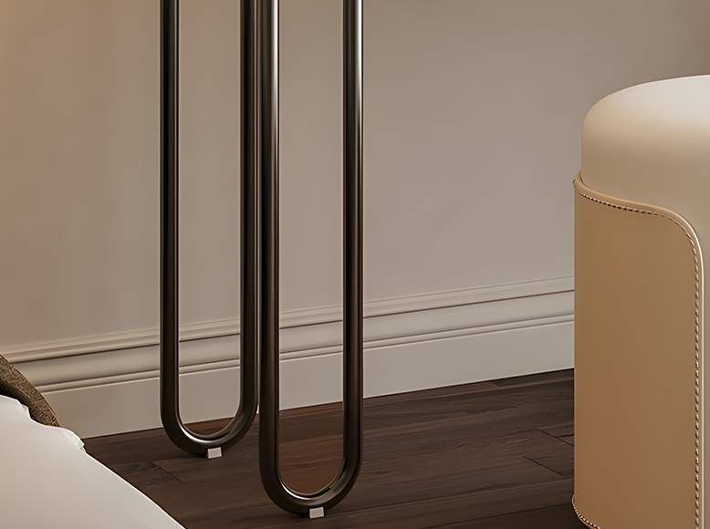 Modern black metal legs against a neutral wall with a beige cushioned stool.