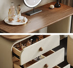 Wooden vanity table with cosmetic items and open drawer revealing more items.