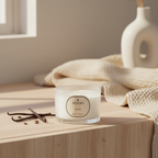 Vanilla candle with 'PARKS' branding on a wooden surface with vanilla beans and a vase in the background.