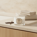Parks Vanilla candle on a wooden surface with folded towels in the background