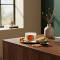 Candle with an orange label on a wooden surface with decorative elements